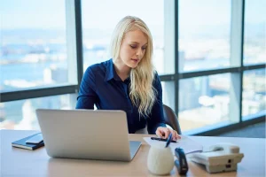 Business professional working at her desk reviewing documents for LLC reinstatement