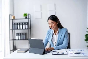 Professional business woman managing dormant LLC compliance and tax filing requirements on laptop in modern office