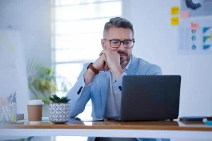 Business owner considering what it means when a company is dissolved while reviewing dissolution paperwork and company closure requirements at office desk