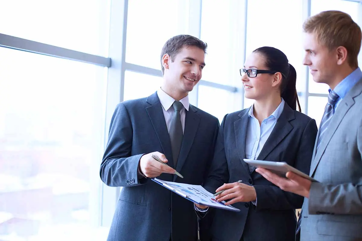 Business professionals reviewing documents while discussing how to register a company as a foreign entity.